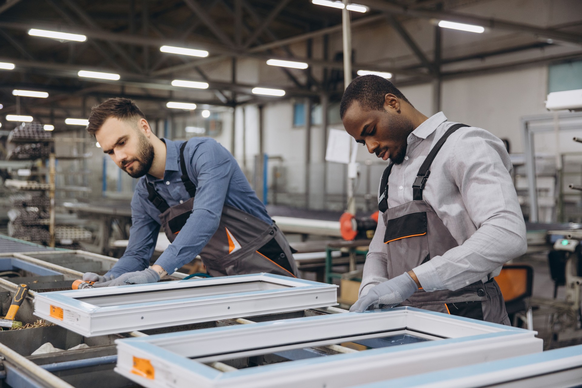 Factory workers assembling PVC windows in production line